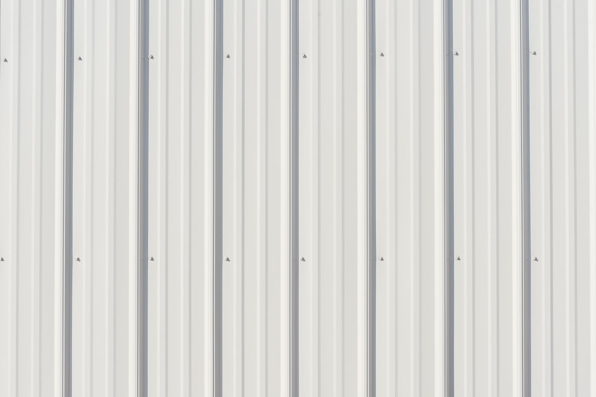 Gray metal siding close up with vertical lines for background