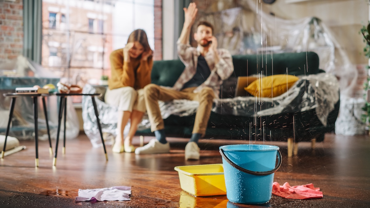 Roof is Leaking, Pipe Rupture at Home: Angry Couple Calling Insurance Company, Screaming into Phone in Frustration, Trying to Find Plumber, Master. Water Drips into Buckets in Living Room. Rack Focus