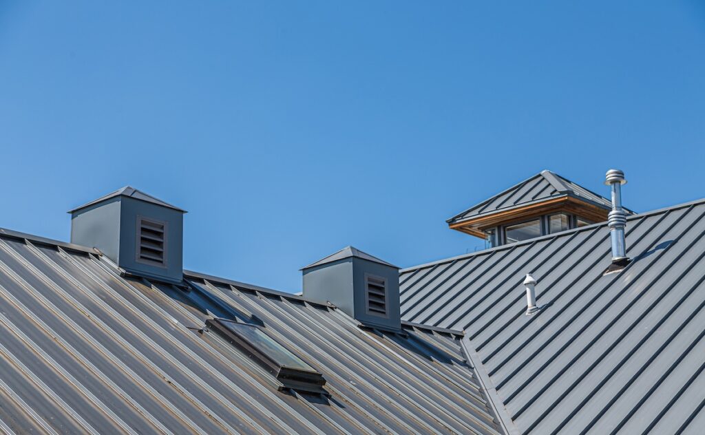 Ribbed Metal Roof and Cupolas Under Blue Skies new metal roof lifespan