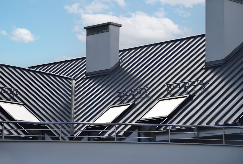 Close-up house retro roof panel with standing seam and fasteners. Classic style black metal panel with rebate joint. Modern galvanized steel roofing sheet with ribs