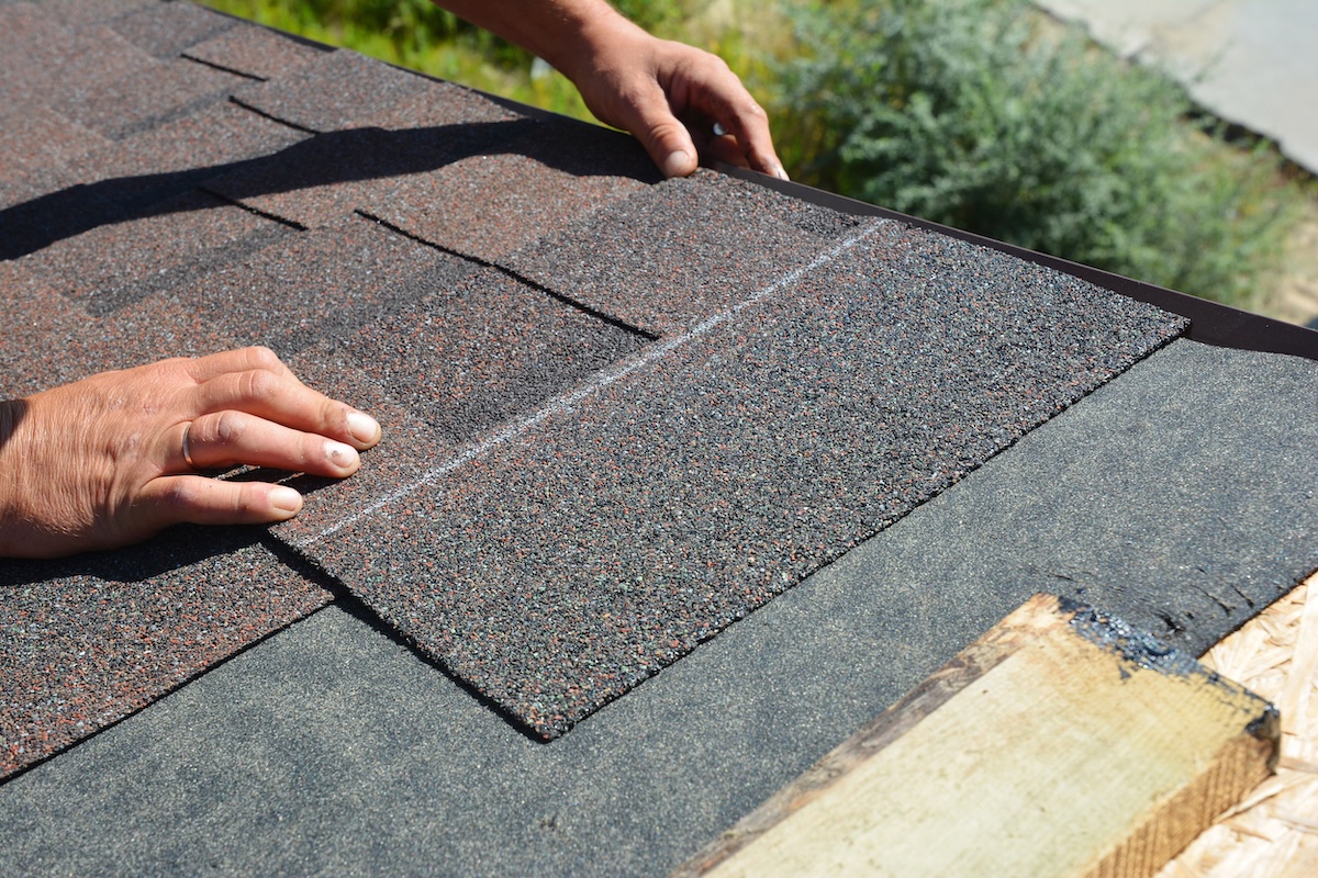 Asphalt Shingles Installation. Roofer Contractor Installing Asphalt Shingles on House Roofing Construction how to install roof shingles