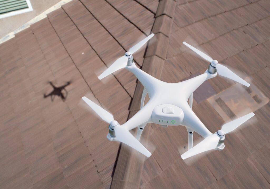 Quadcopter UAV Drone Flying A Residential Roof Inspection.