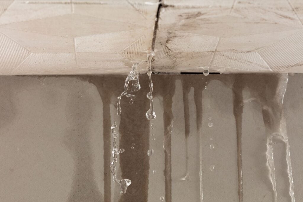 Heavy storm rain create water flow from edge of ceiling and dirty stain on wall