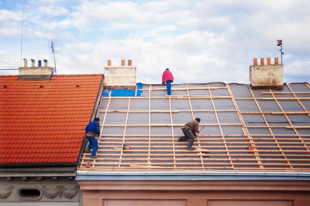 three builders replace the tiled roof