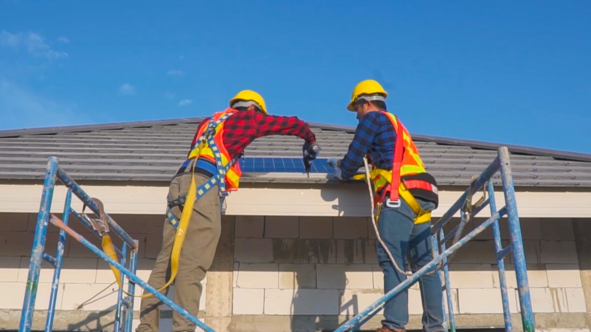 built up roofing two workers standing on platform