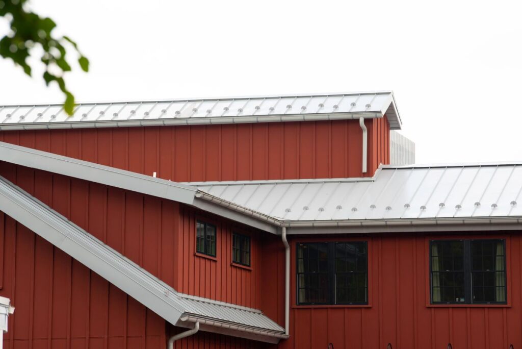 metal roof accents red siding big house black windows