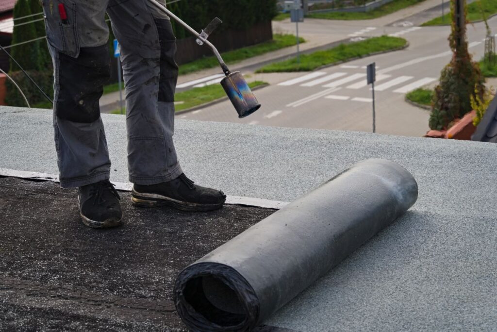 roof felt worker installing roller