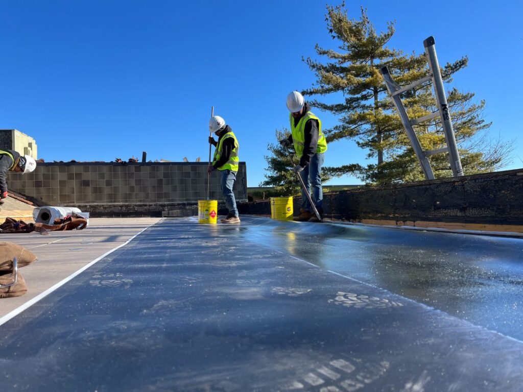 built up roofing Maumee River project worker applying EDPM on top of building