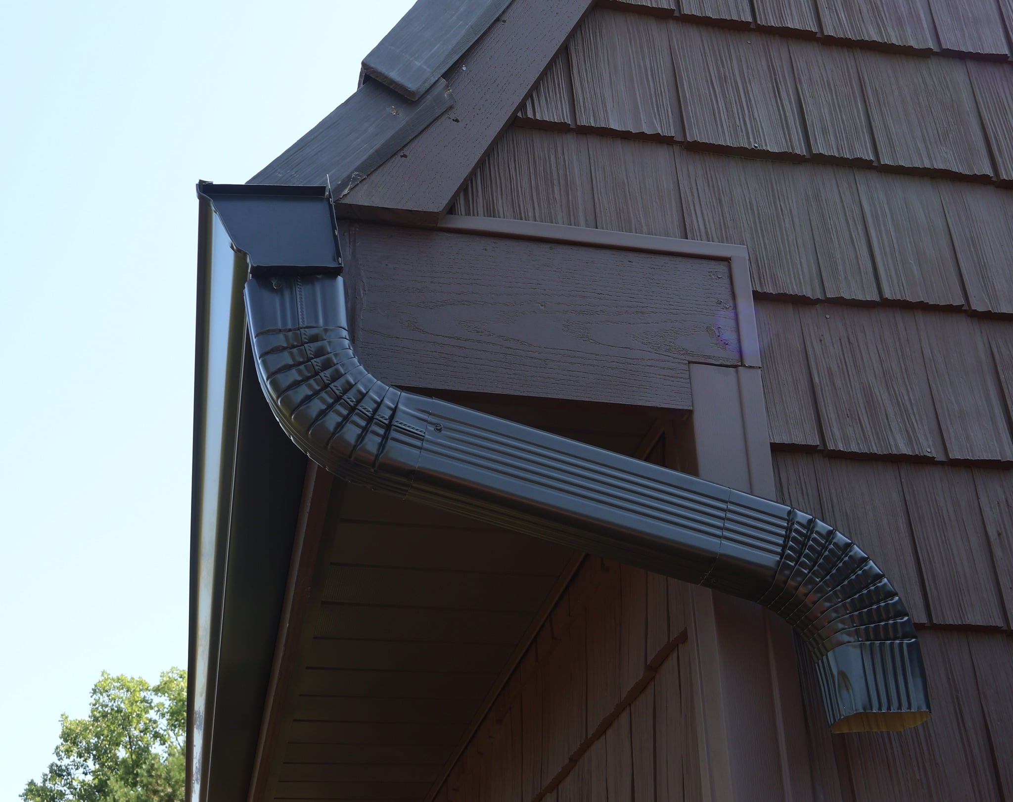 Close-up of a gutter downspout getting installed
