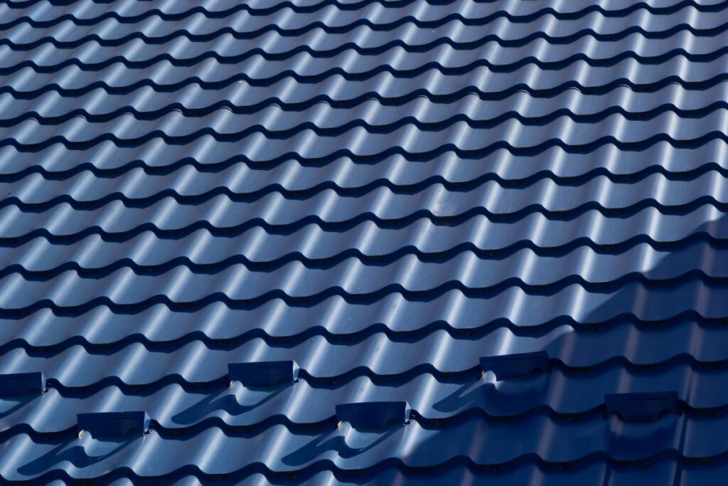 The roof of a house covered with sheets of blue metal tiles
