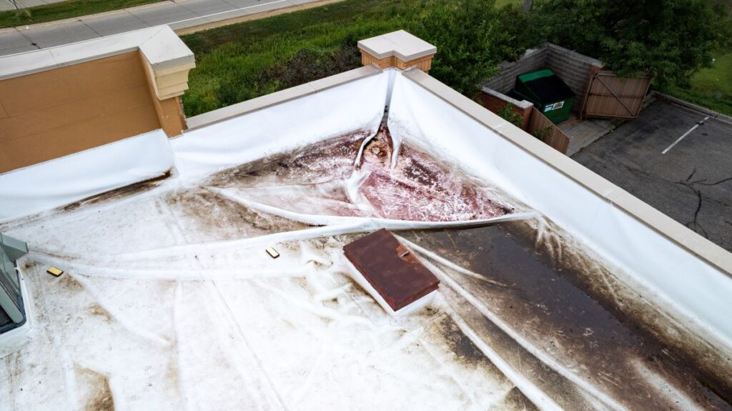 Aerial View of Damaged Commercial Flat Roof with Ponding Water and Stains