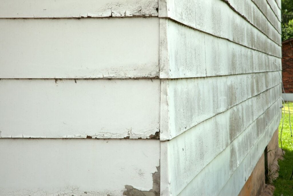 Close-up of a vinyl siding, showing damage and age