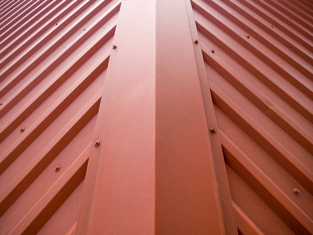 Fragment of the roof of a building covered with a metal, metal roof ridge cap