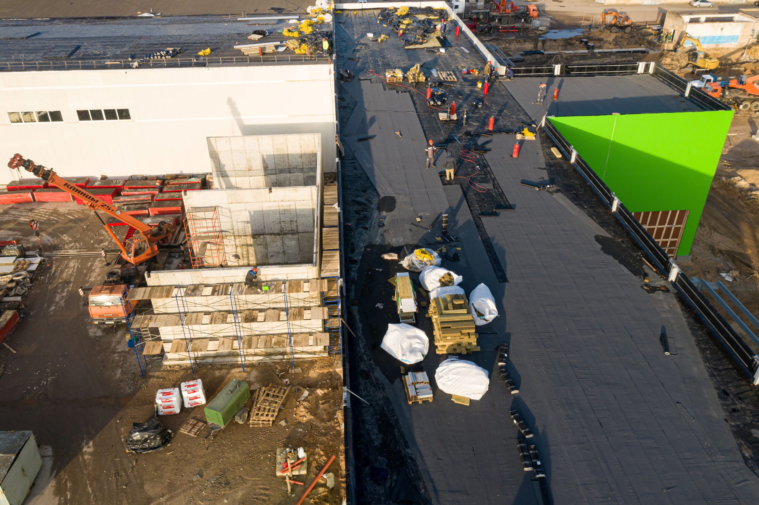 workers make a commercial roof waterproof