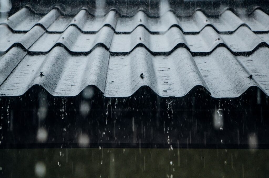 rain flows down from a metal roof